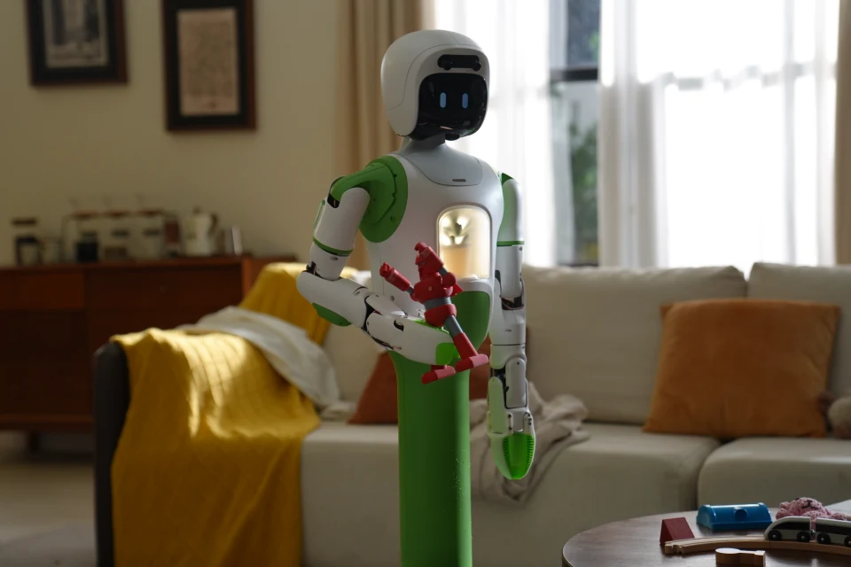 Homebot One KOKO holding a red toy in a sunlit living room