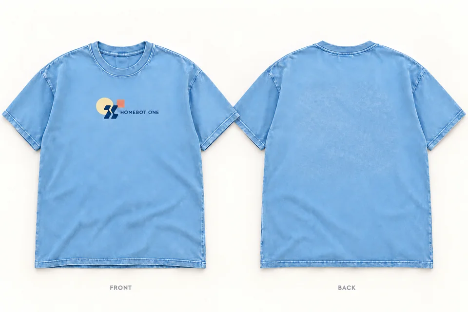 Front and back of a washed sky-blue T-shirt with a navy Homebot One logo, a pale sun and a coral square across the chest.