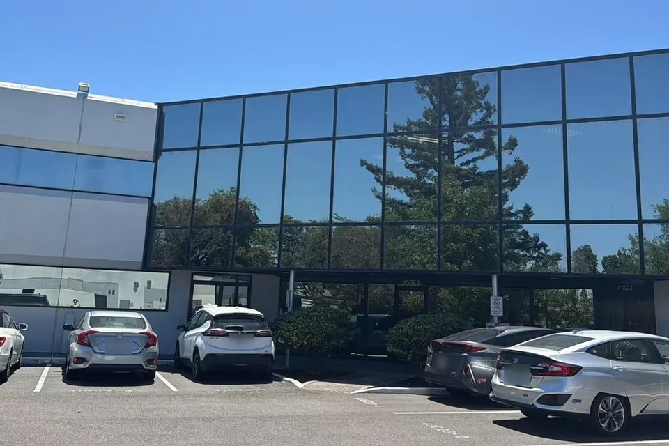 The Homebot One Inc office in Fremont, California: a two-story building with a wall of blue glass windows.